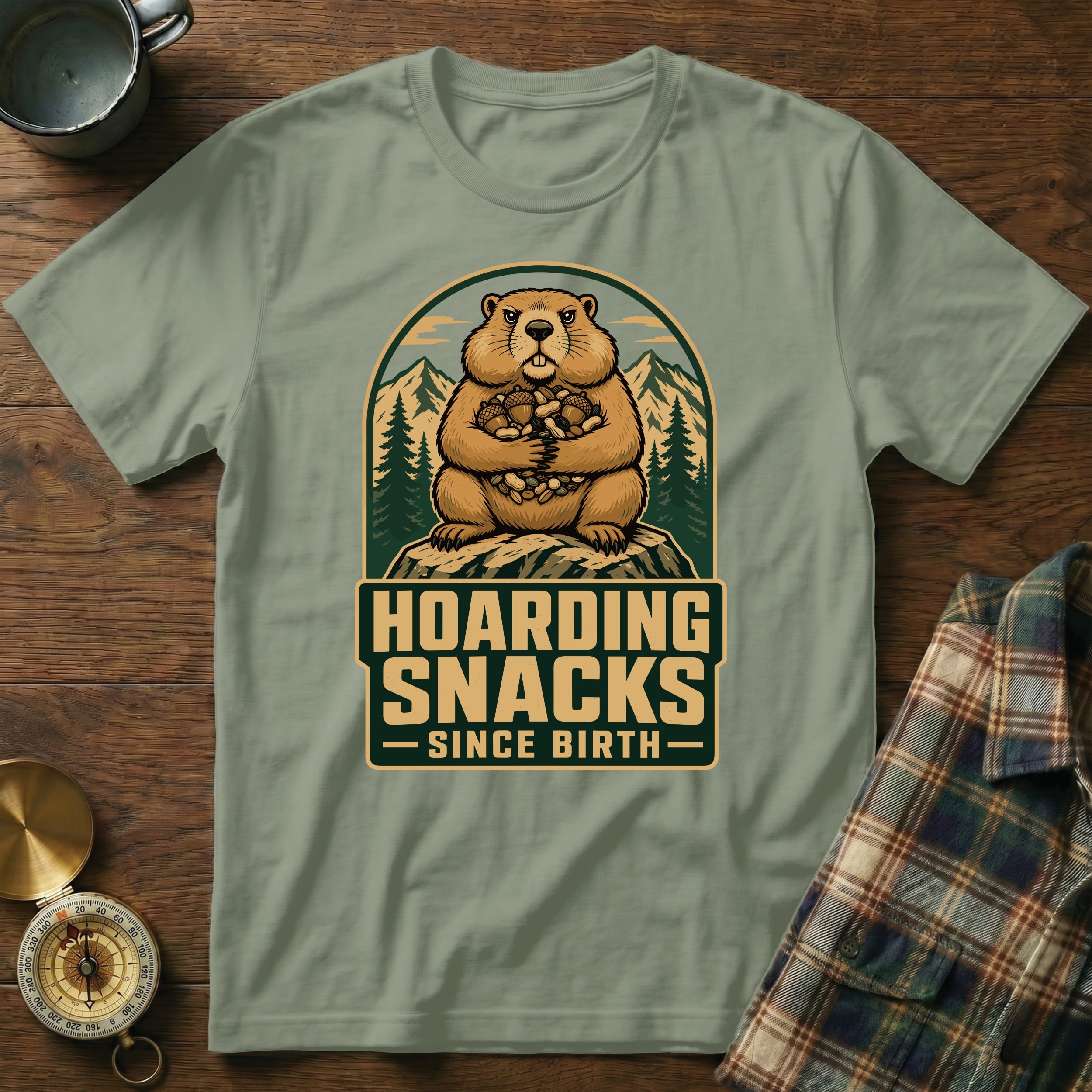 Groundhog hoarding snacks since birth graphic on a green t-shirt.