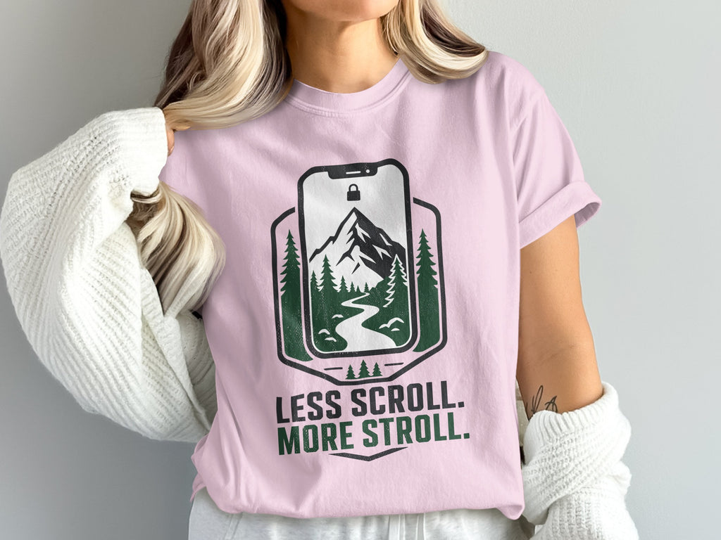 Pink t-shirt with "Less Scroll. More Stroll." text and nature graphic.