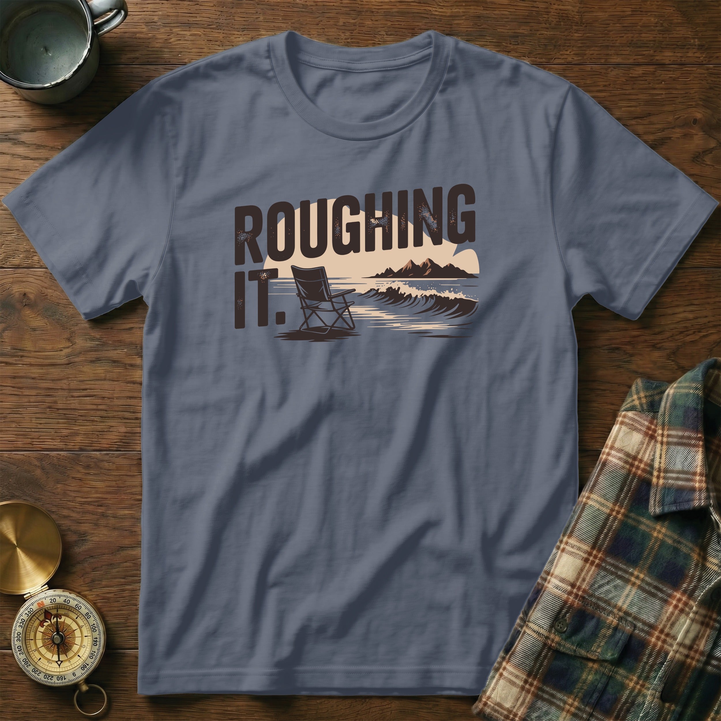 Blue t-shirt with "ROUGHING IT." text and outdoor scene graphic.