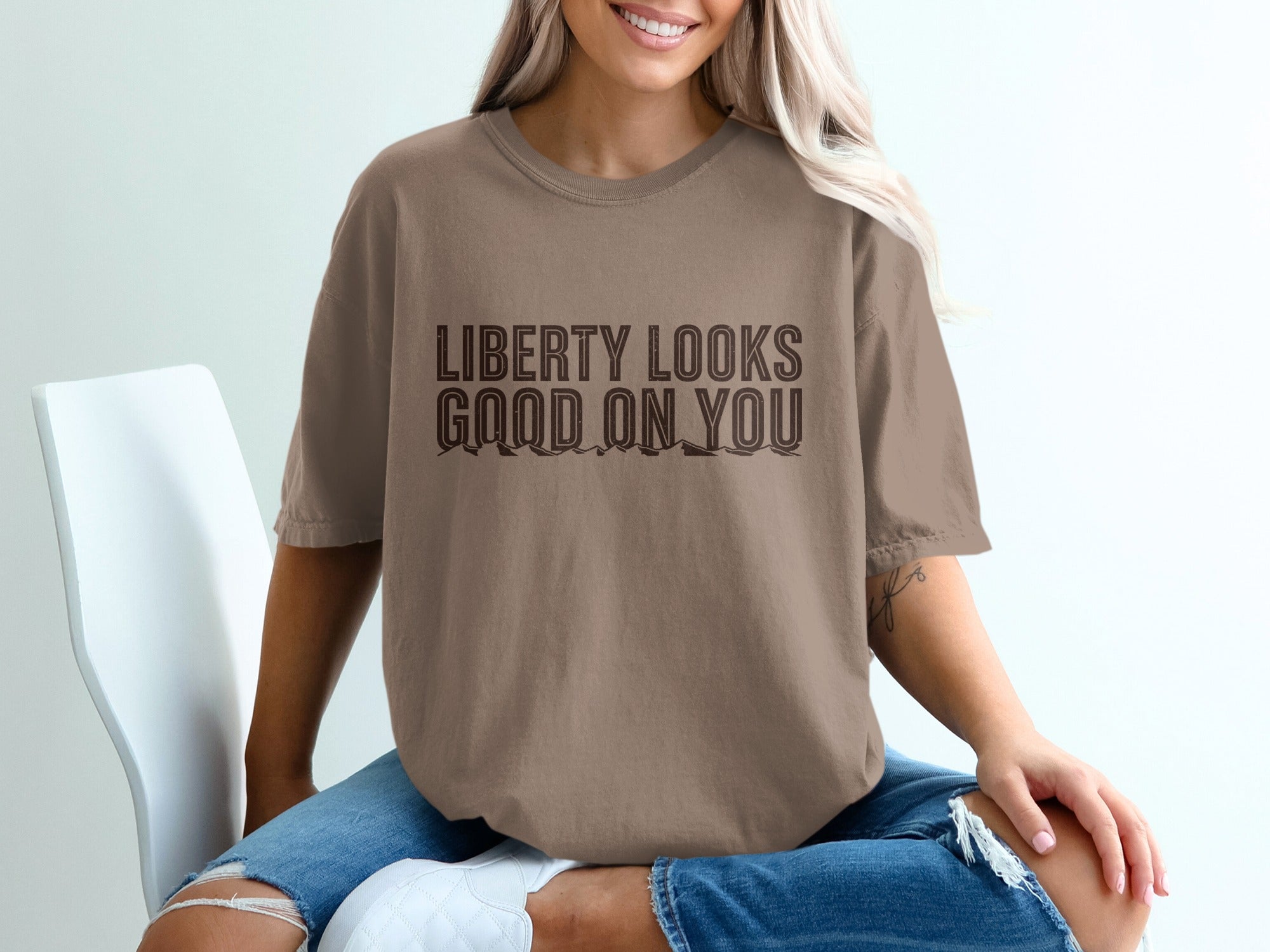T-shirt with "LIBERTY LOOKS GOOD ON YOU" text and mountains graphic.