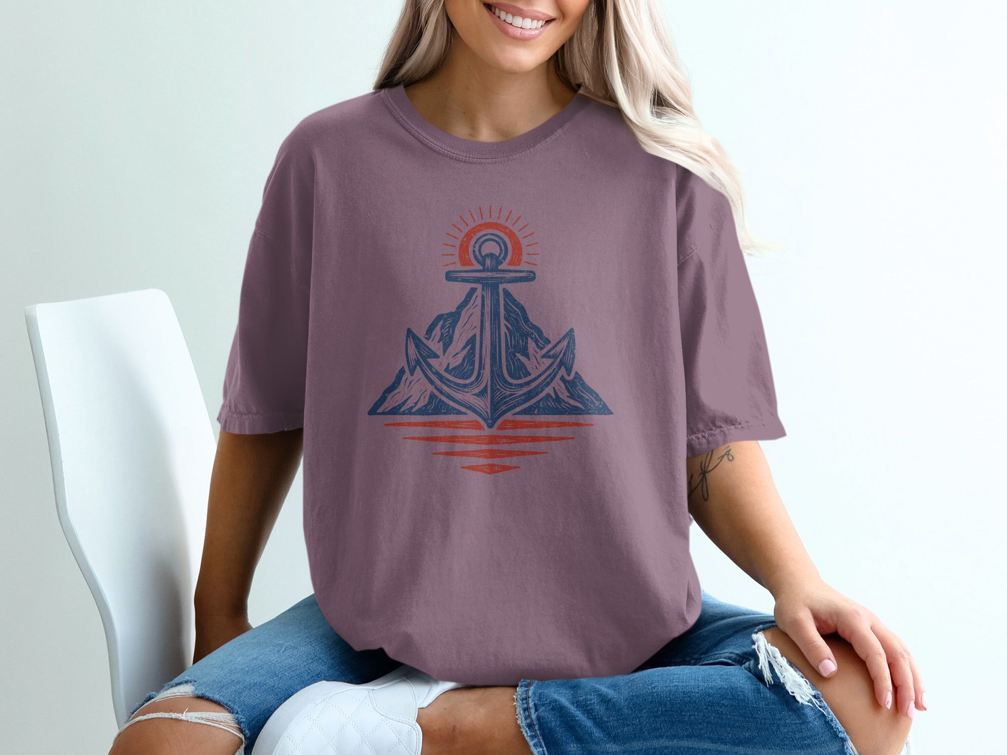 Purple t-shirt with anchor, mountain, and sun graphic.
