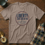 Brown t-shirt with "Liberty Looks Good On You" text and mountain graphic.