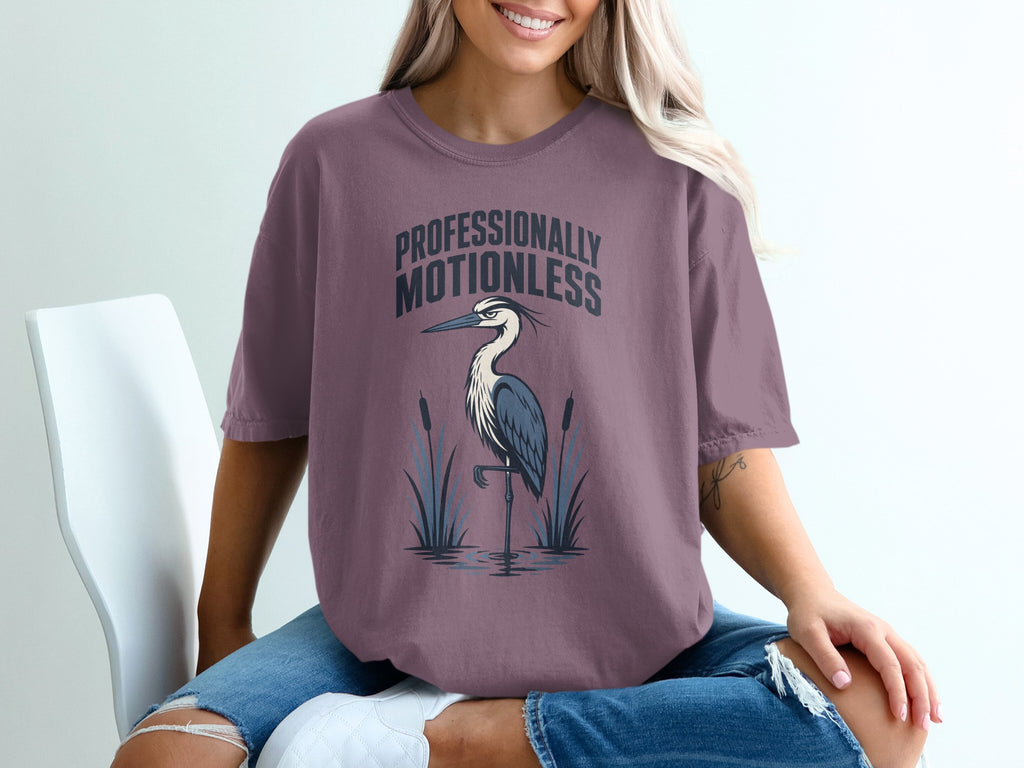 T-shirt with text "PROFESSIONALLY MOTIONLESS" and a heron standing in water.