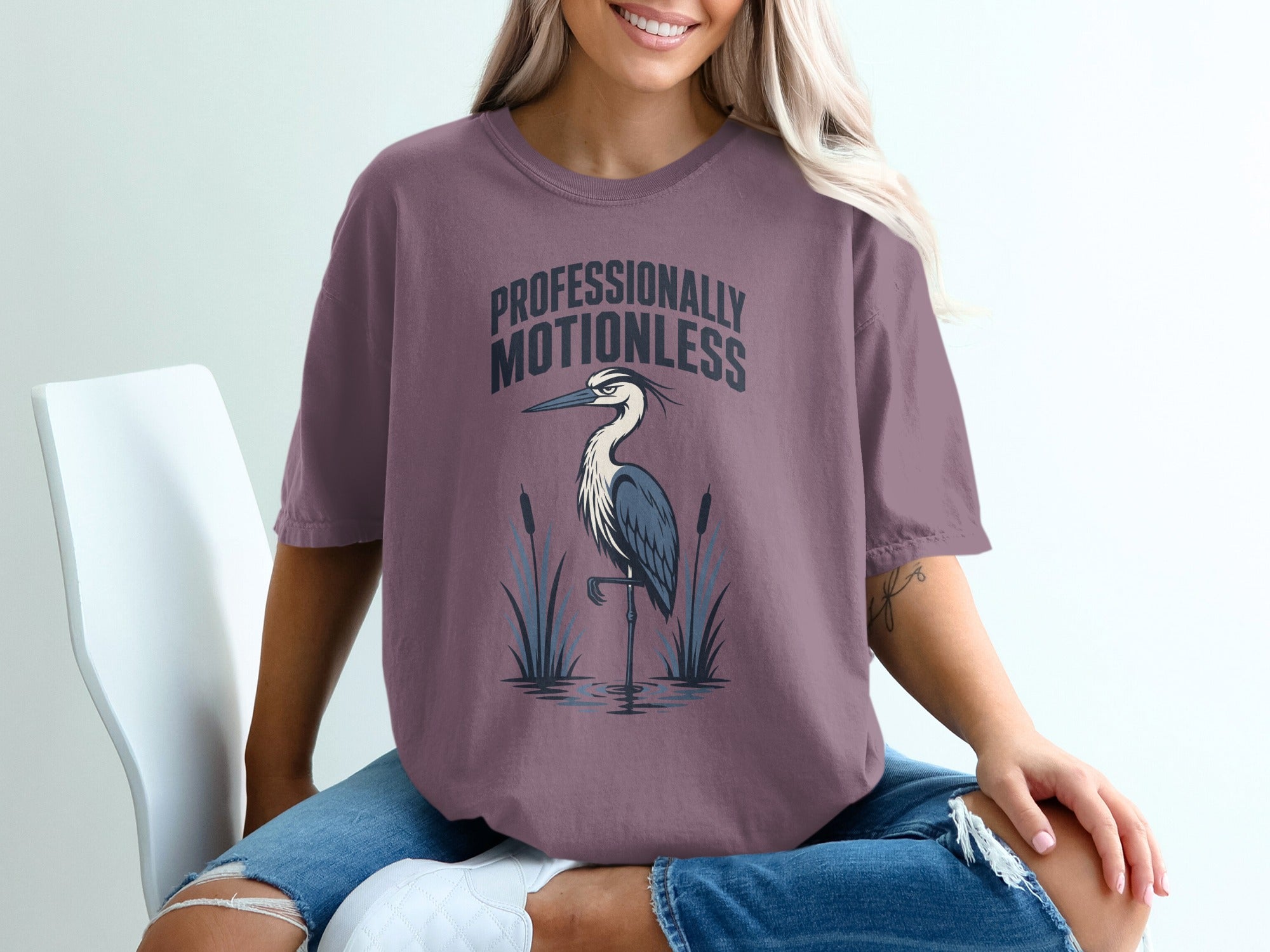 T-shirt with text "PROFESSIONALLY MOTIONLESS" and a heron standing in water.