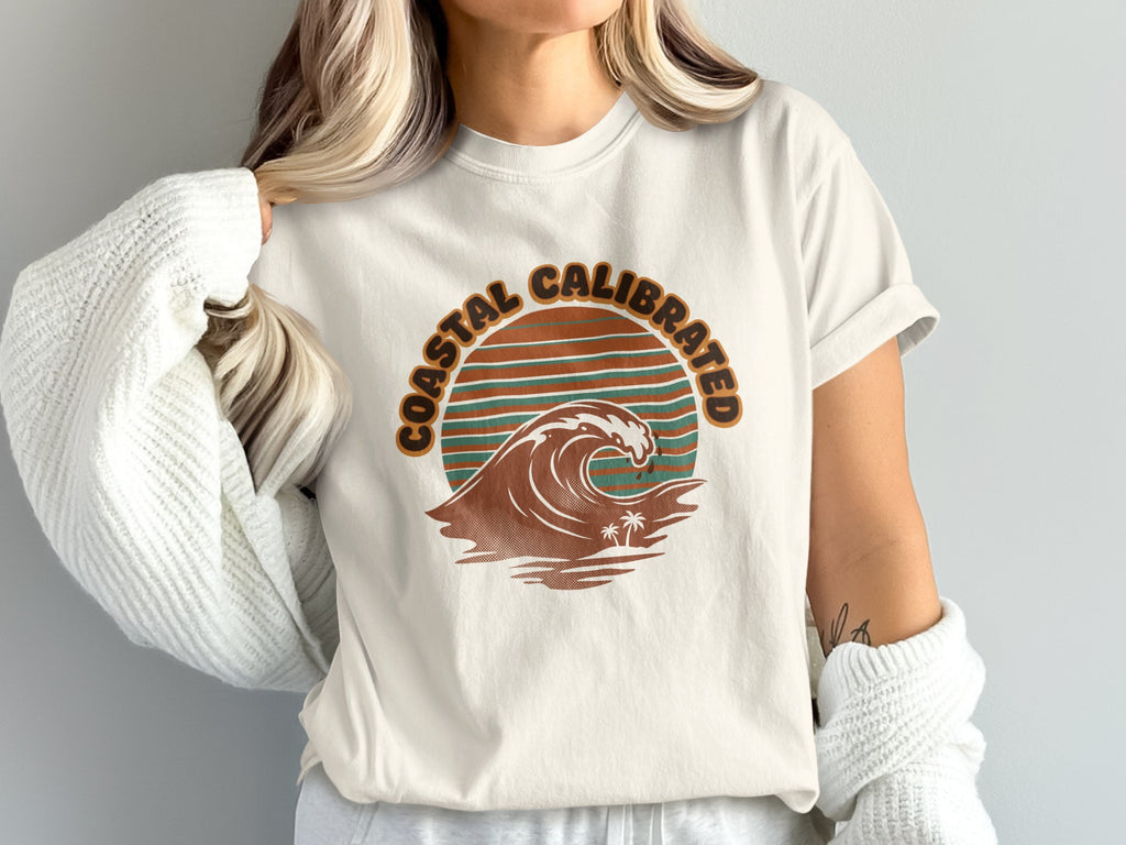 Cream t-shirt with "Coastal Calibrated" text and a wave graphic.