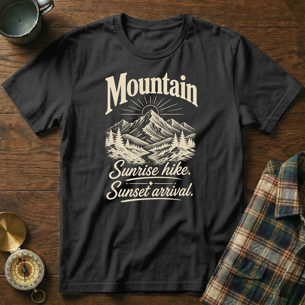 Black crewneck t-shirt featuring a mountain graphic and the text Mountain Sunrise hike. Sunset arrival.