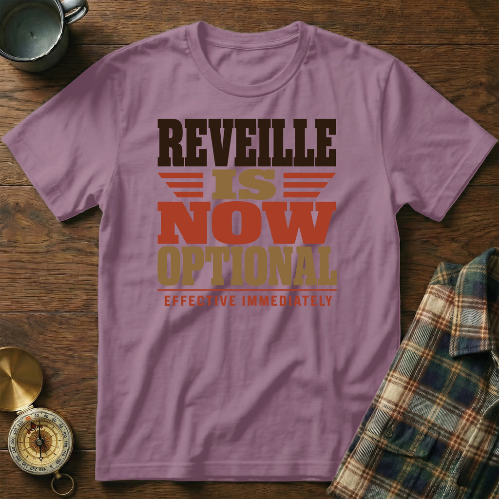 A mauve short-sleeve t-shirt with brown, gold, and red text reading "REVEILLE IS NOW OPTIONAL EFFECTIVE IMMEDIATELY".
