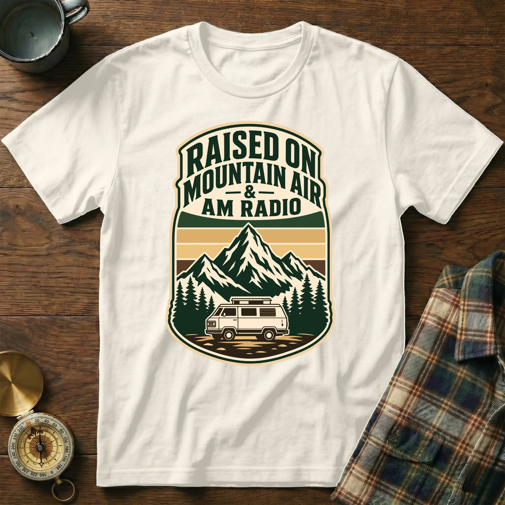 White t-shirt graphic with text "Raised On Mountain Air & AM Radio" and a retro van.