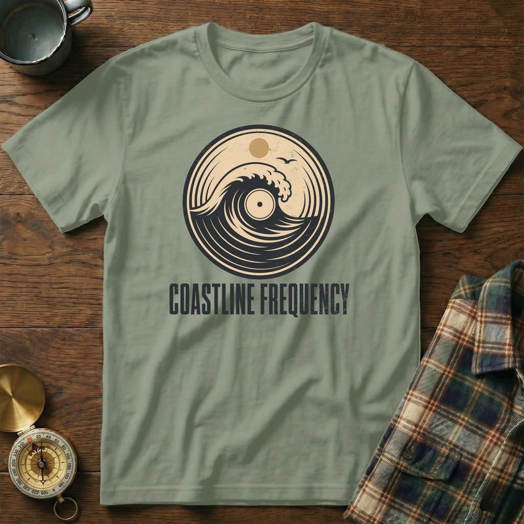 Olive green t-shirt with "Coastline Frequency" text and vinyl record wave graphic.