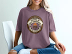 T-shirt with "Survived an Adult Conversation" merit badge graphic.