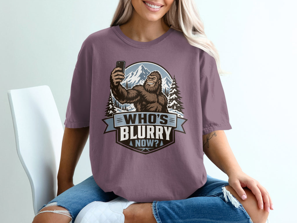 Bigfoot taking a selfie with mountains and text that reads "WHO'S BLURRY NOW?".