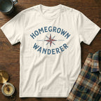 White t-shirt with "HOMEGROWN WANDERER" text and compass graphic.