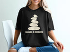 Black t-shirt with stacked stones graphic and text "BALANCE IS OVERRATED."