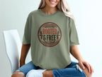 Green t-shirt with circular "ROOTED & FREE" graphic and leafy accents.