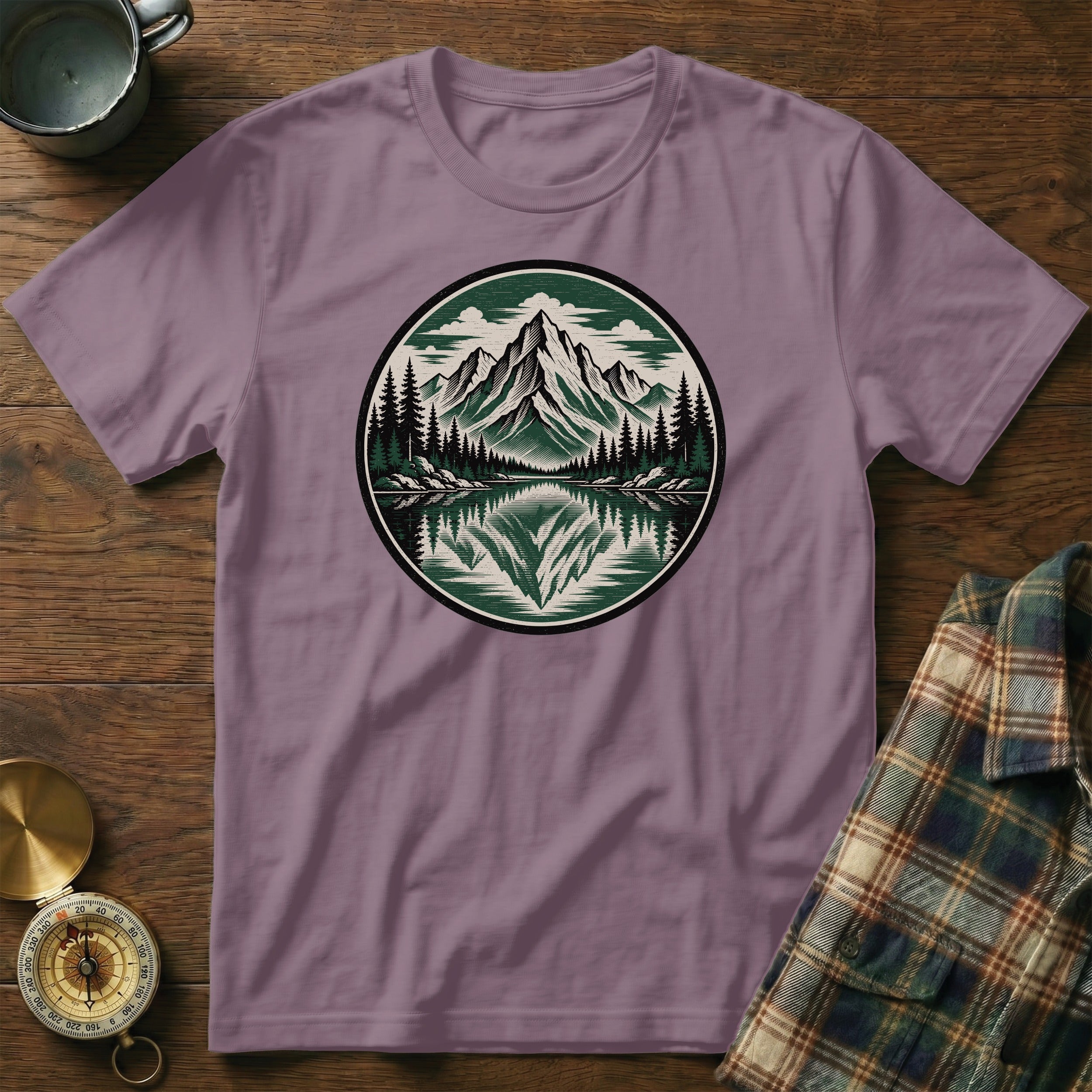 Purple t-shirt with a circular mountain landscape graphic and compass.