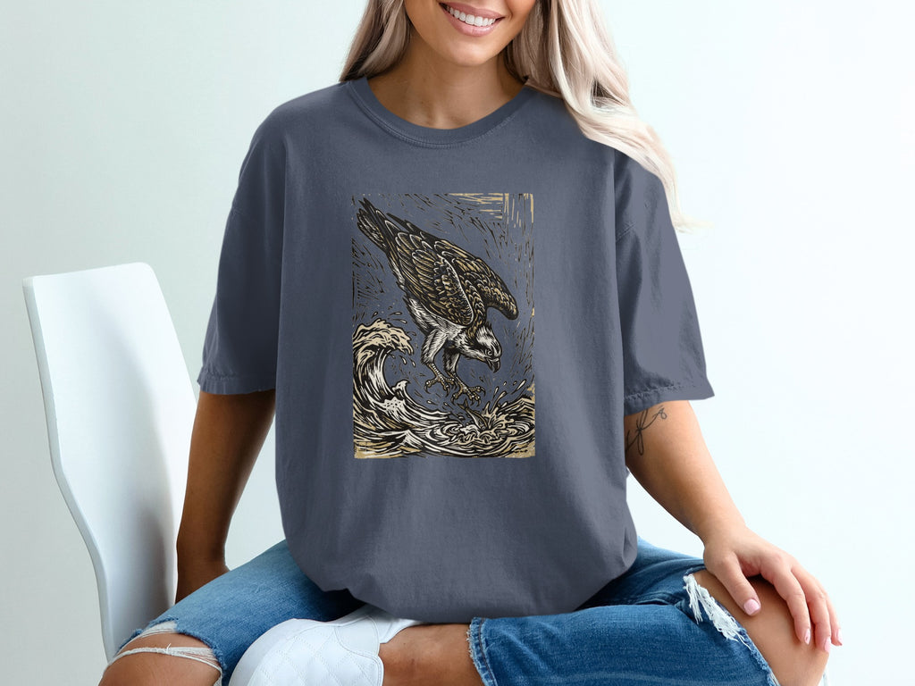 T-shirt featuring an osprey diving for fish in rough waves.