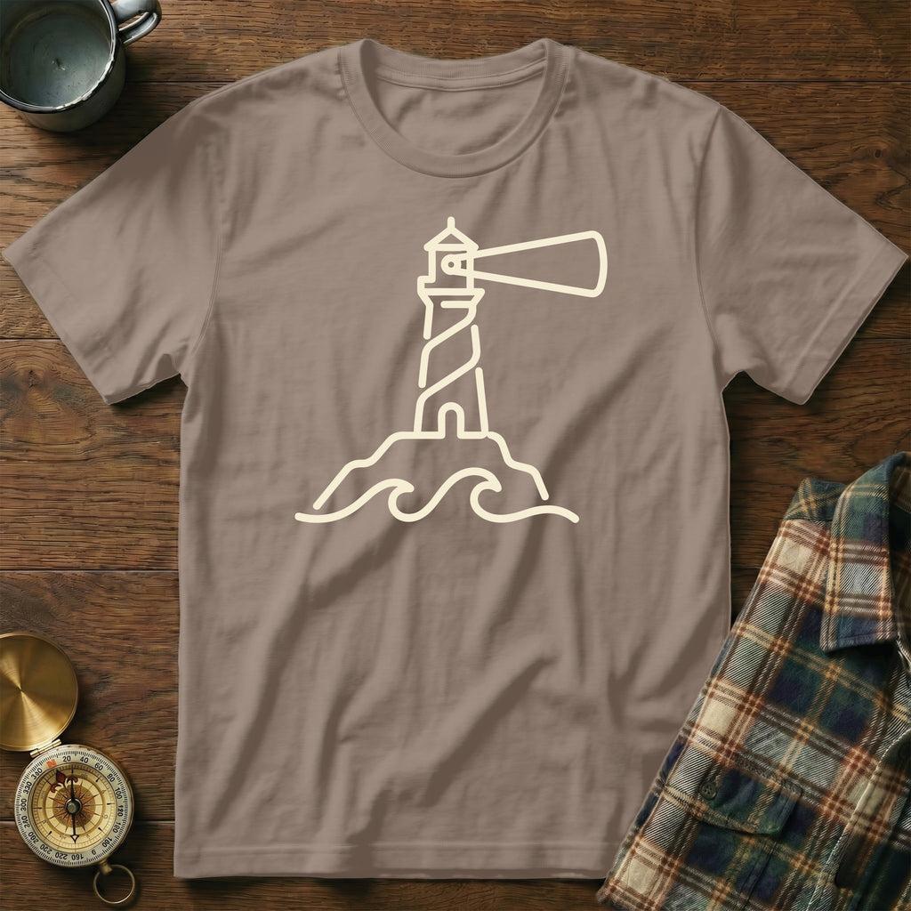 Taupe t-shirt with a cream line-art lighthouse and waves graphic.