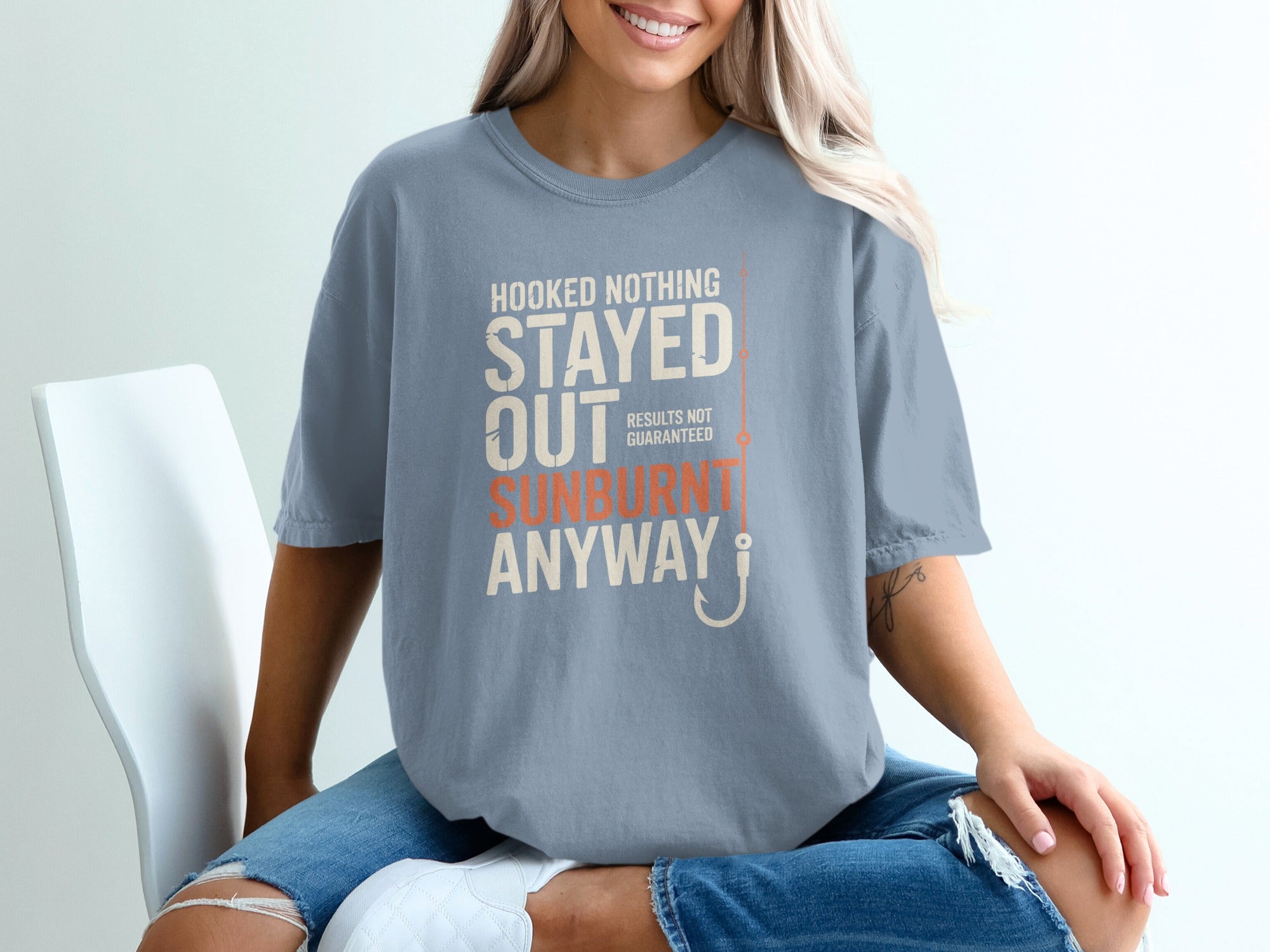 Blue t-shirt with text "HOOKED NOTHING STAYED OUT SUNBURNT ANYWAY" and a fish hook.
