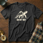 Black t-shirt with graphic of turtle with backpack and text "ON MY WAY".