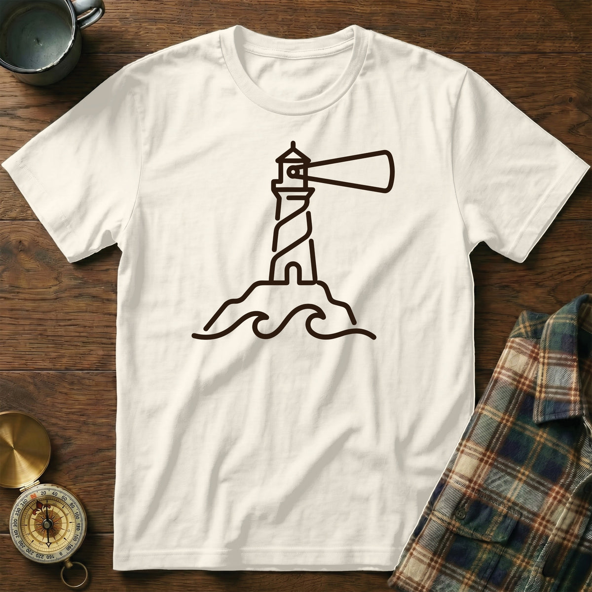 White t-shirt with a dark brown line drawing of a lighthouse on a rock with waves.