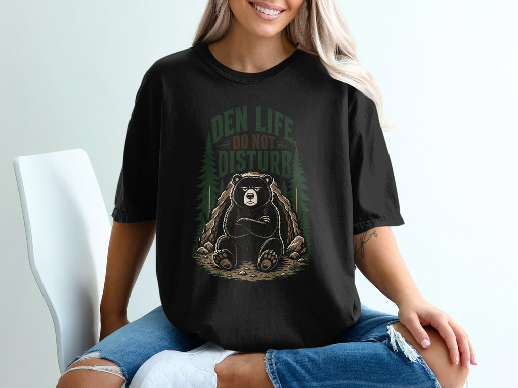Black t-shirt graphic with bear at den entrance, text reads "Den Life Do Not Disturb".