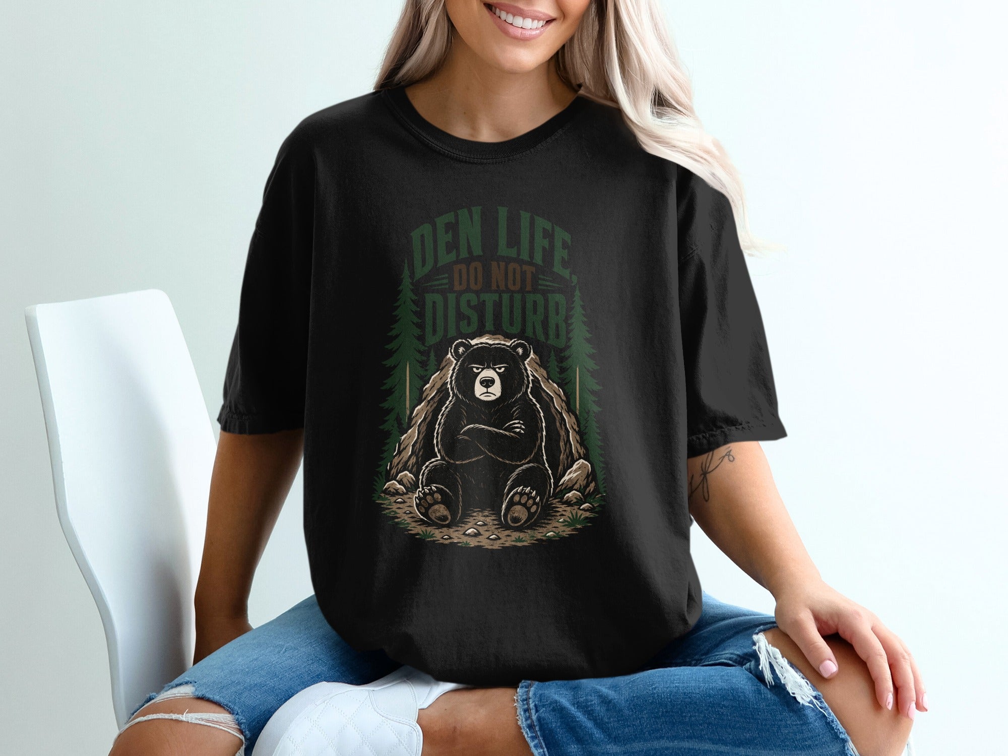 Black t-shirt graphic with bear at den entrance, text reads "Den Life Do Not Disturb".