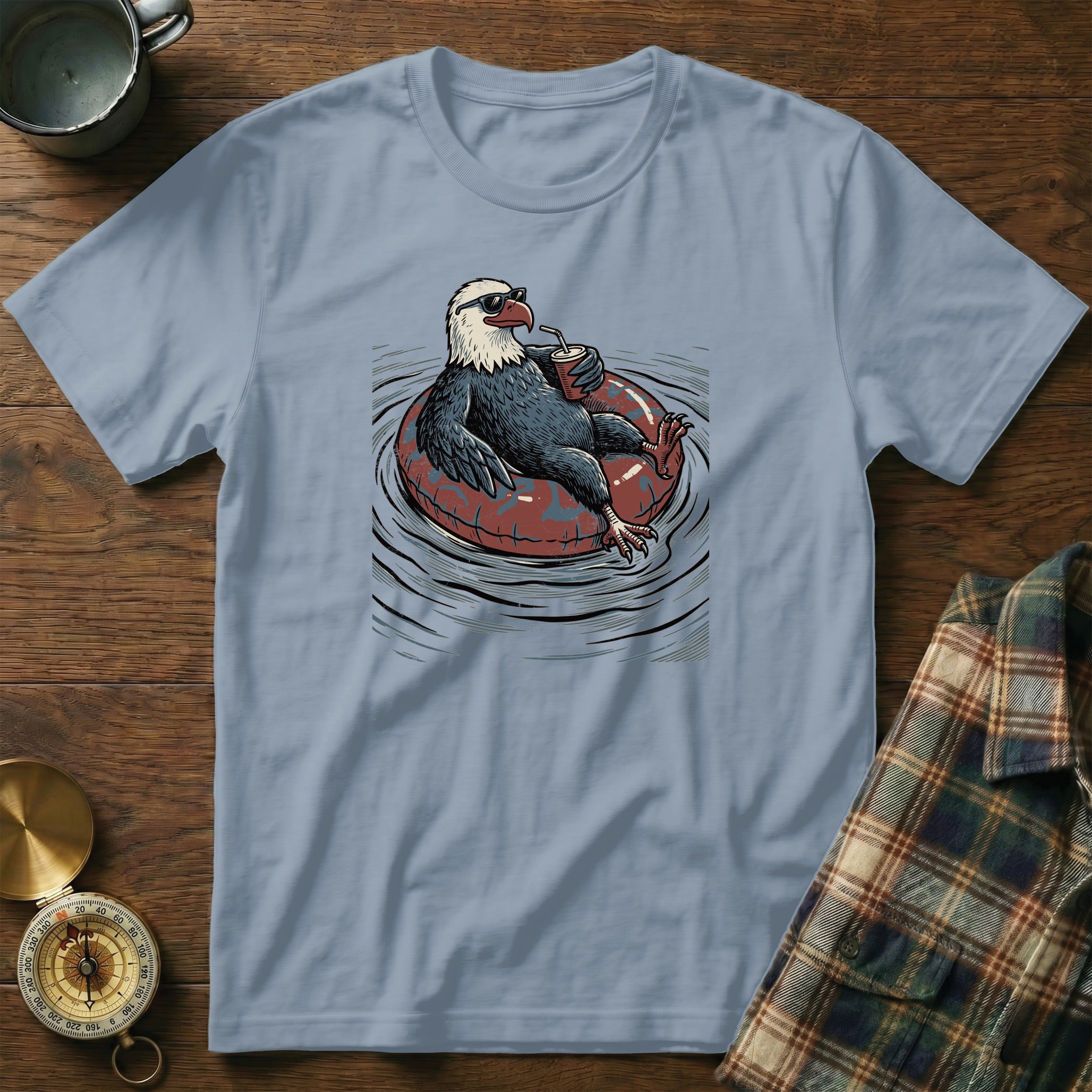 Eagle wearing sunglasses relaxes on an inner tube, holding a drink.