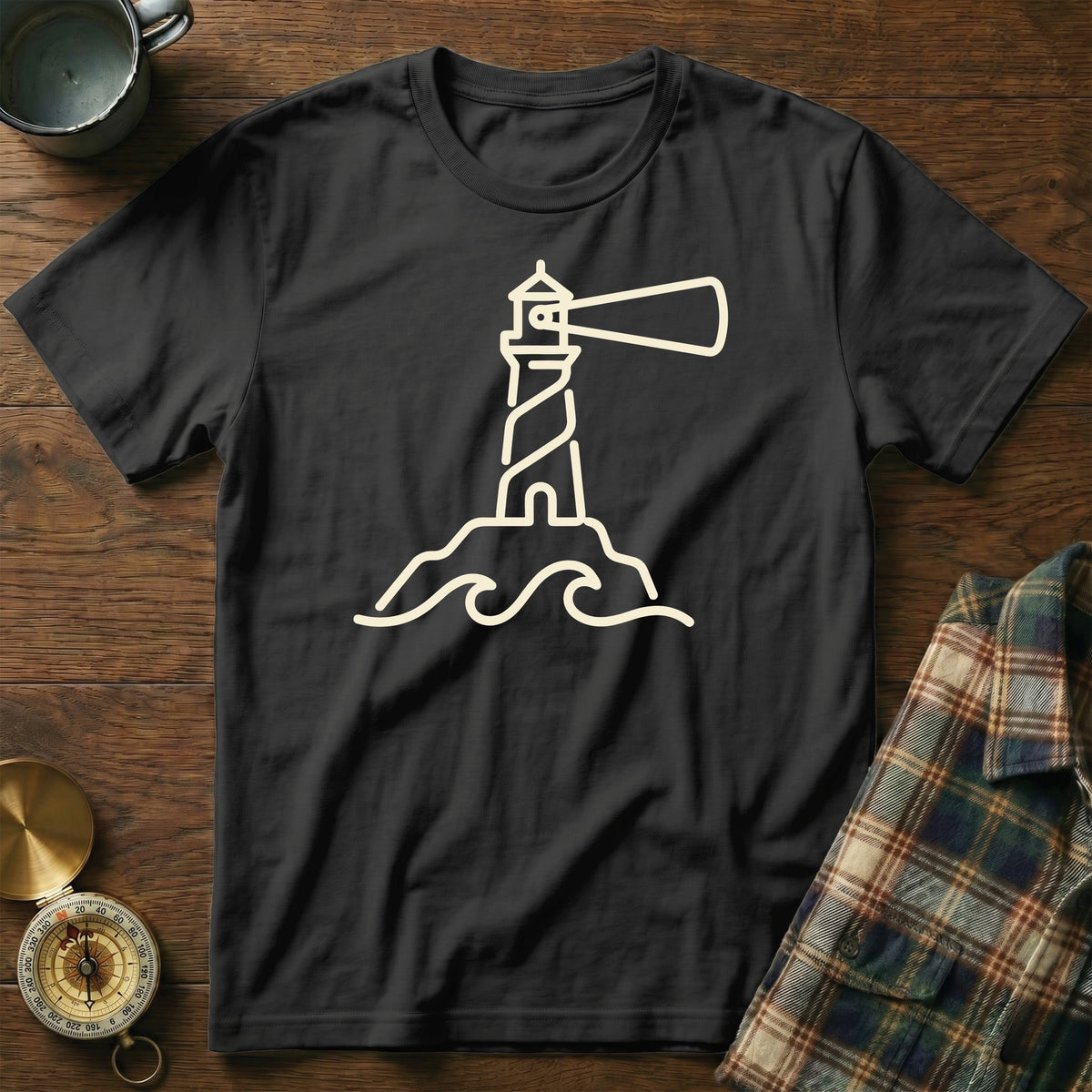Black t-shirt with a cream line art of a lighthouse on a rock with waves.