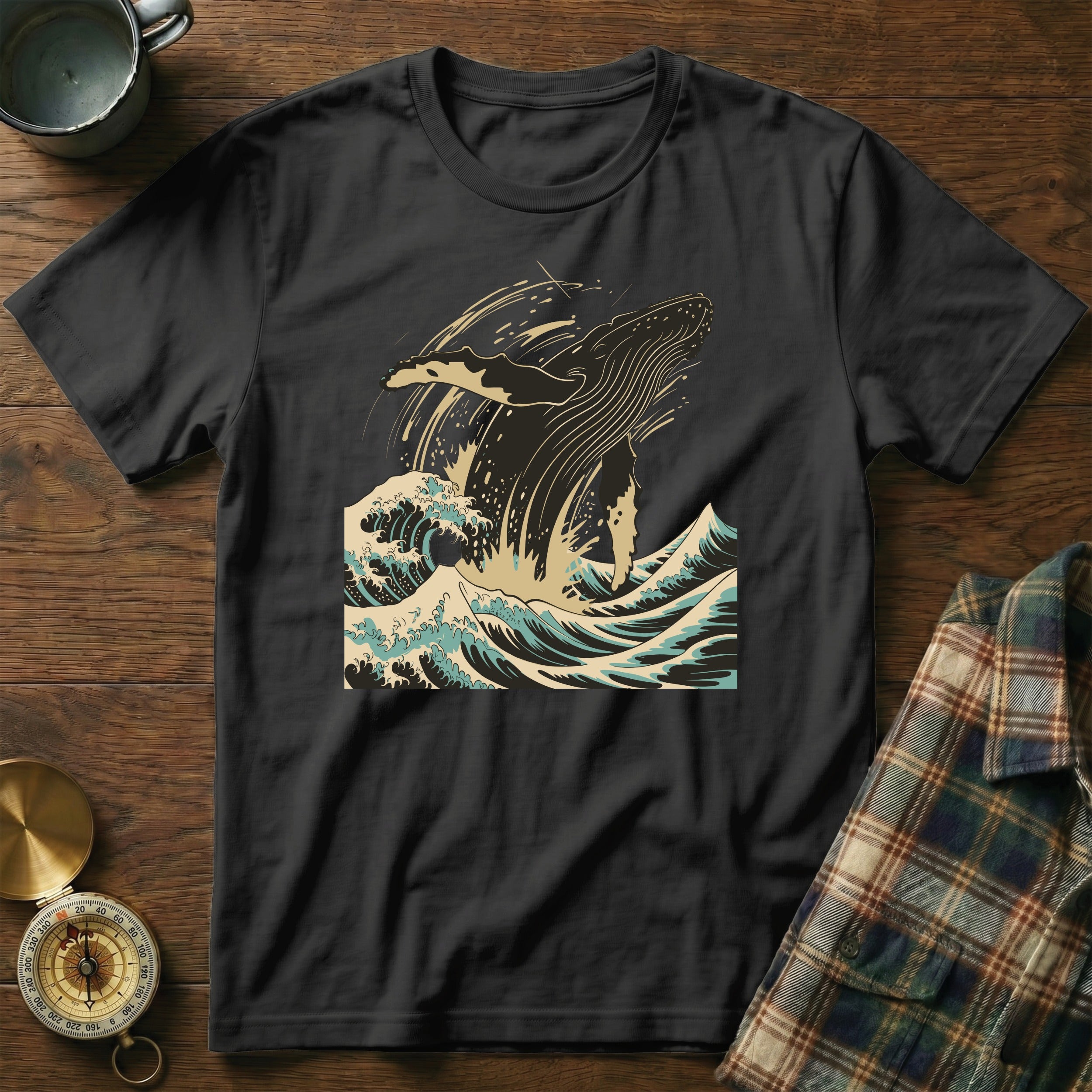 Black t-shirt with whale breaching in stylized waves graphic.