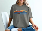 Graphic of a canoer on a lake with colorful mountains in the background.