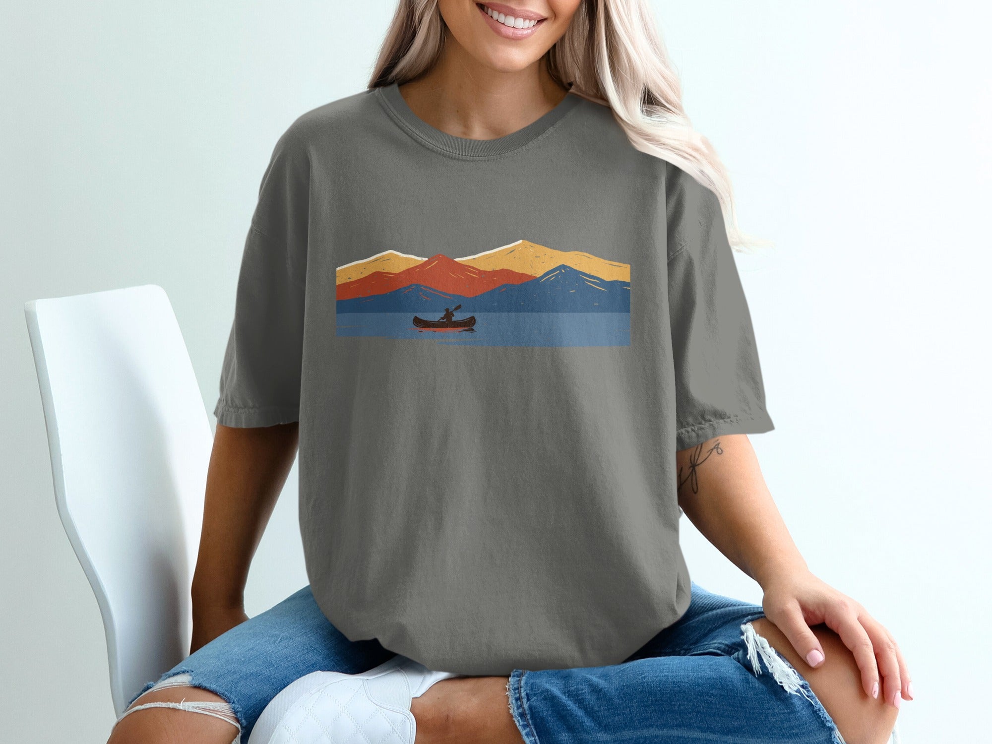 Graphic of a canoer on a lake with colorful mountains in the background.