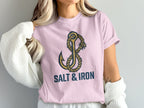 Pink t-shirt with nautical anchor and rope graphic, text reads "SALT & IRON".