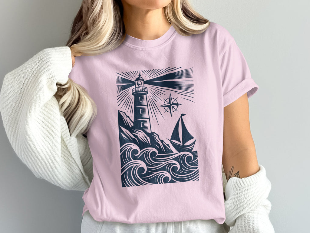 Pink t-shirt with navy lighthouse, boat, and waves graphic.