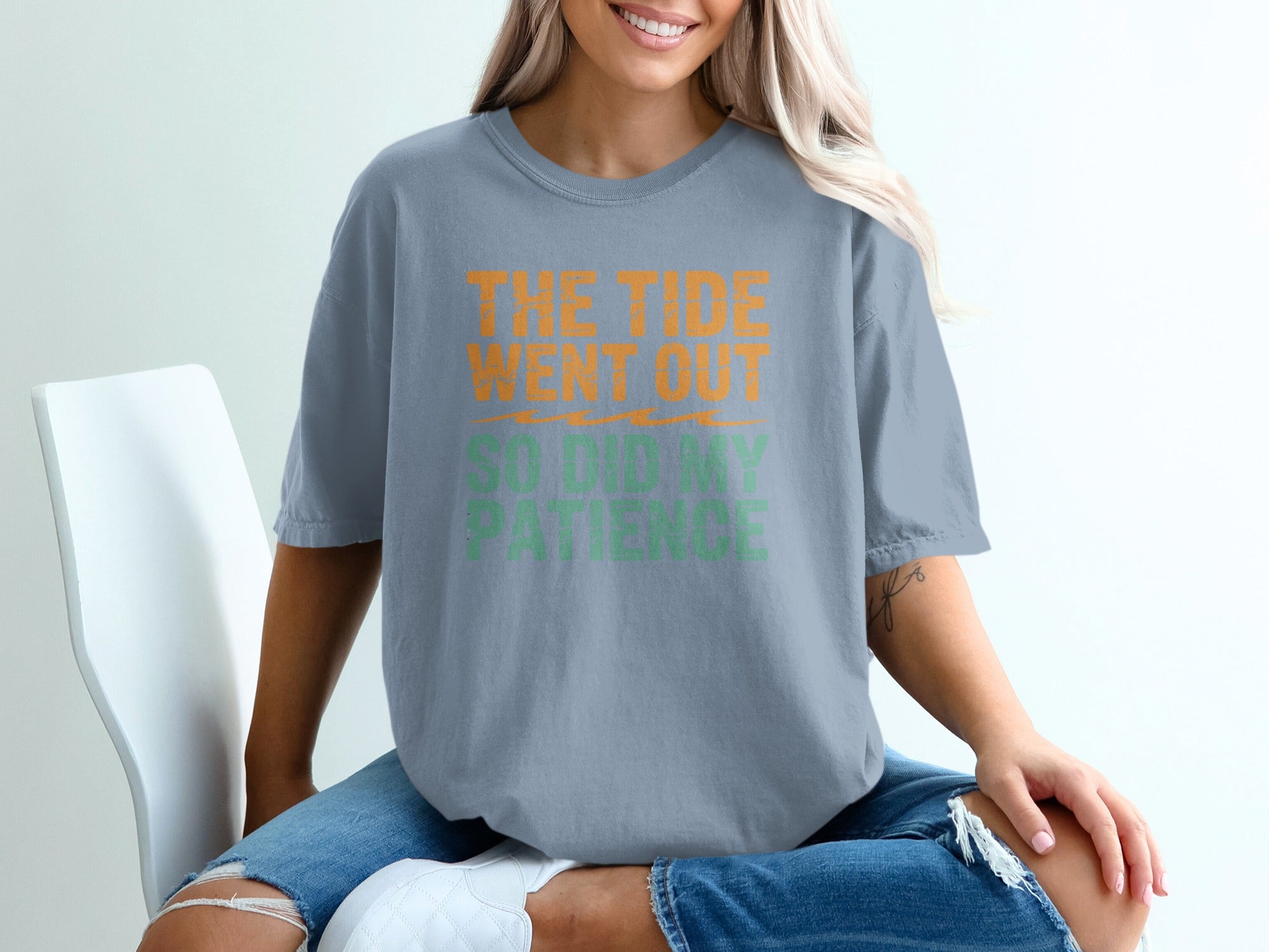 Blue t-shirt with orange and green text reading "The tide went out so did my patience".