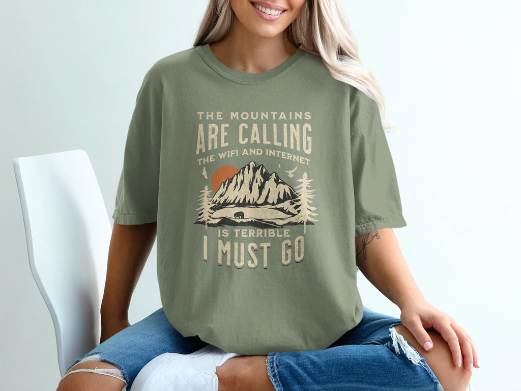 T-shirt with "The mountains are calling, the wifi and internet I must go" text and mountain graphic.