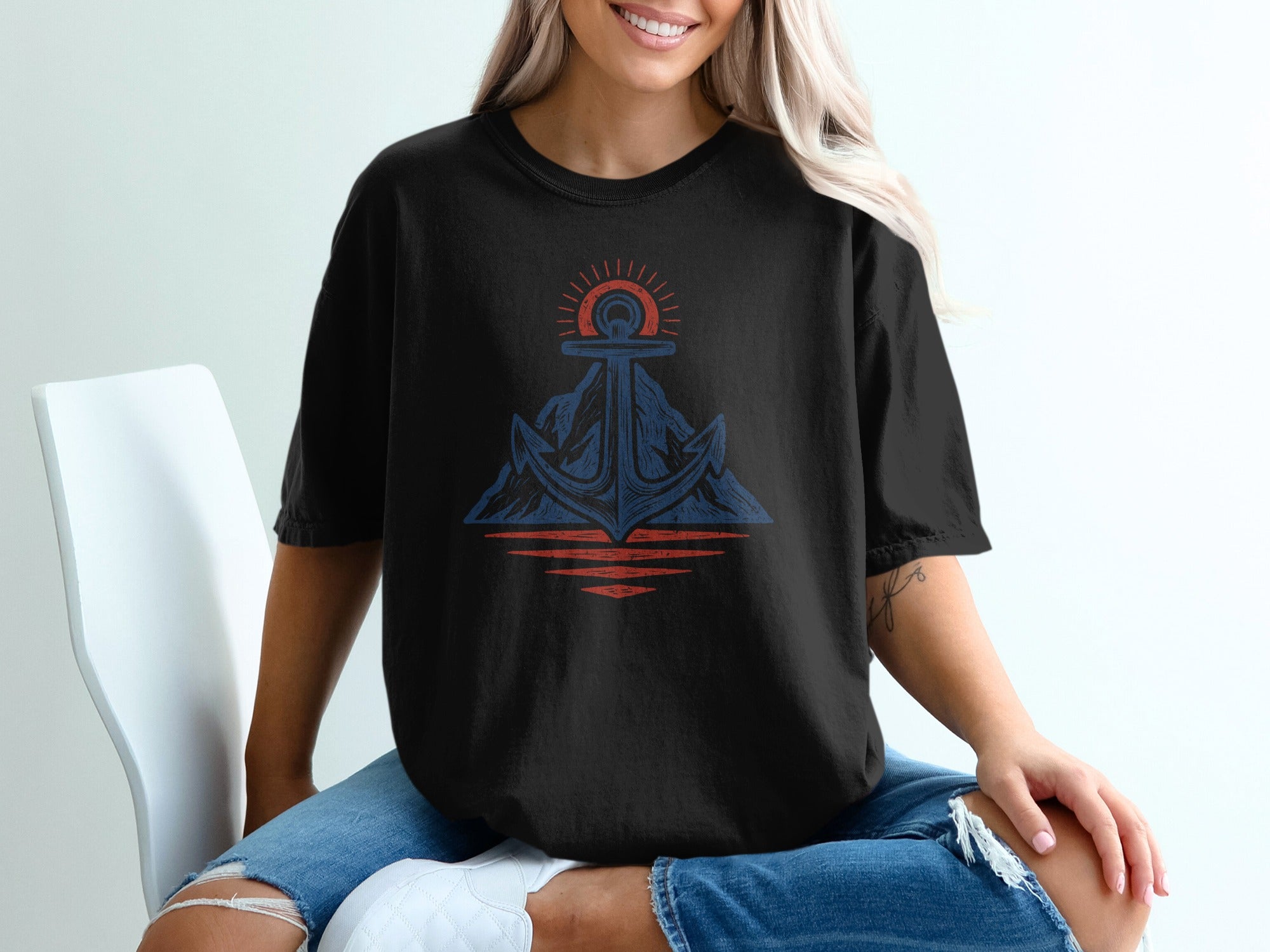 Black t-shirt with blue and red anchor, mountain, and sun graphic.