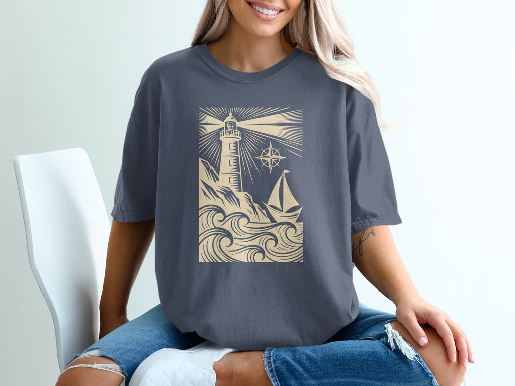 T-shirt graphic: lighthouse, sailboat, waves, and compass rose.