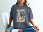 T-shirt graphic: lighthouse, sailboat, waves, and compass rose.