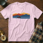 Pink t-shirt with a graphic of a canoeist on a lake with abstract mountains.
