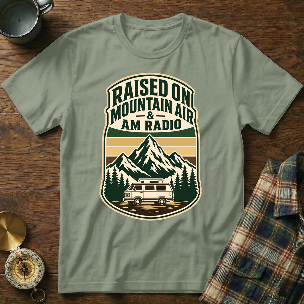 T-shirt with "Raised on Mountain Air & AM Radio" text and van, mountains, and trees graphic.