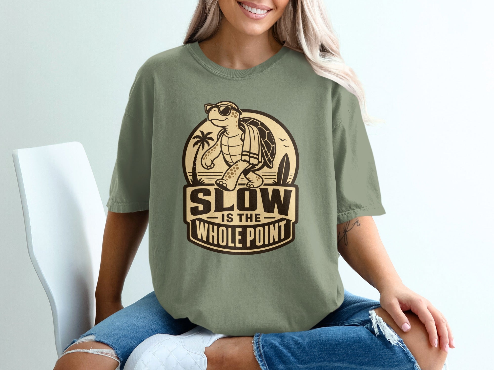 T-shirt with a graphic of a turtle wearing sunglasses, text "SLOW IS THE WHOLE POINT".