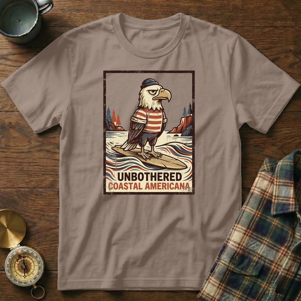 T-shirt with illustration of an eagle surfing and text "UNBOTHERED COASTAL AMERICANA".