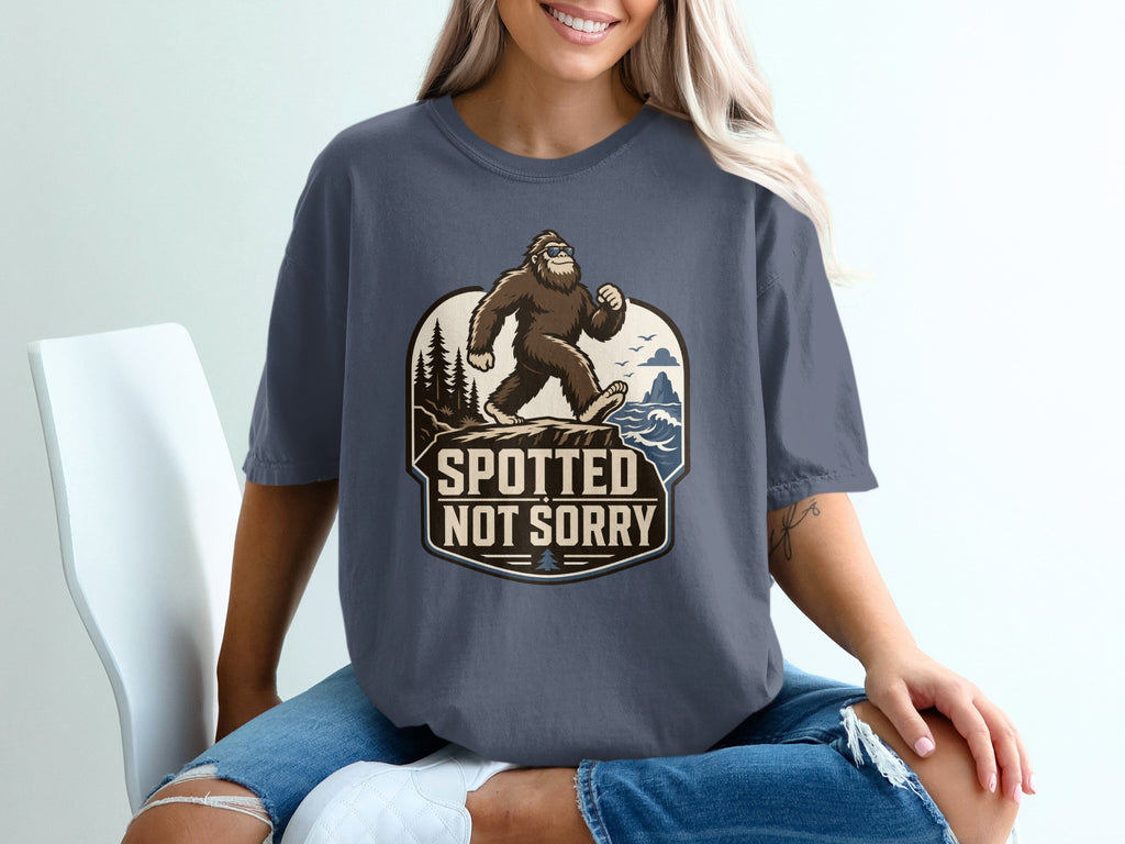 Bigfoot wearing sunglasses walks on a cliff with text "SPOTTED NOT SORRY".