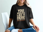 Black t-shirt with "YOU WOULDN'T LIKE IT HERE" and "COLD WATER. WIND. NO COMPLAINTS." text.