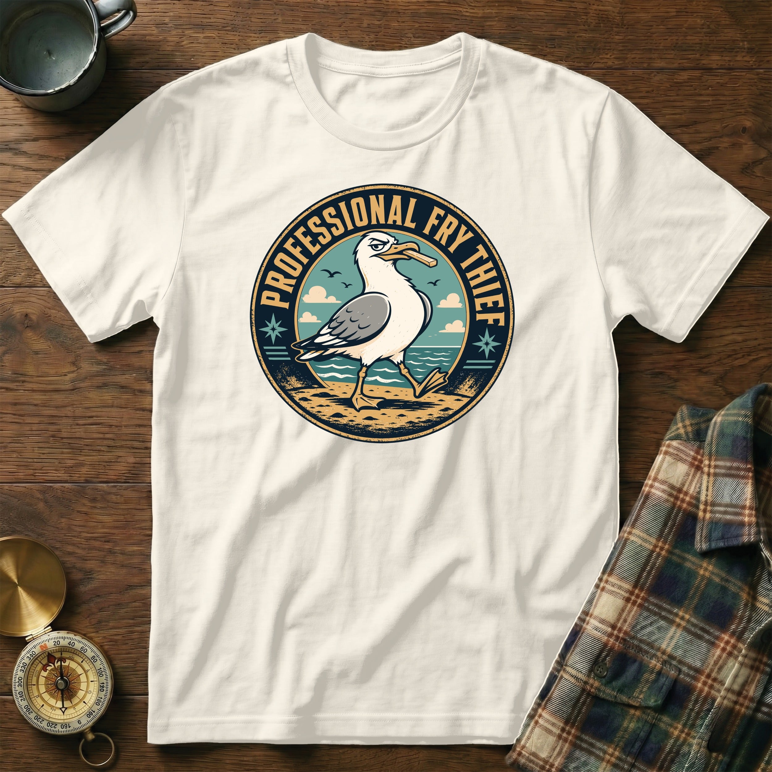 White t-shirt with a circular graphic of a seagull holding a french fry, reading "Professional Fry Thief."
