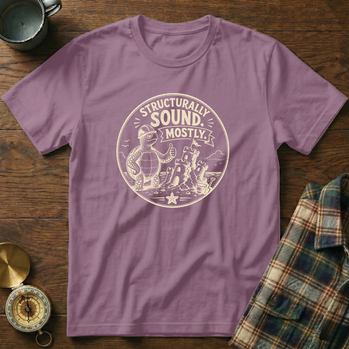 Lavender t-shirt with a graphic of a turtle giving a thumbs up near a sandcastle.