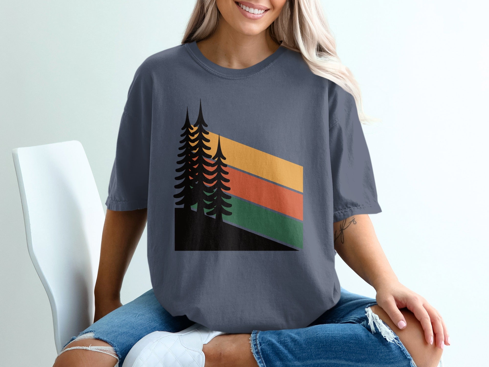 Dark blue t-shirt with abstract tree line and striped sunset graphic.