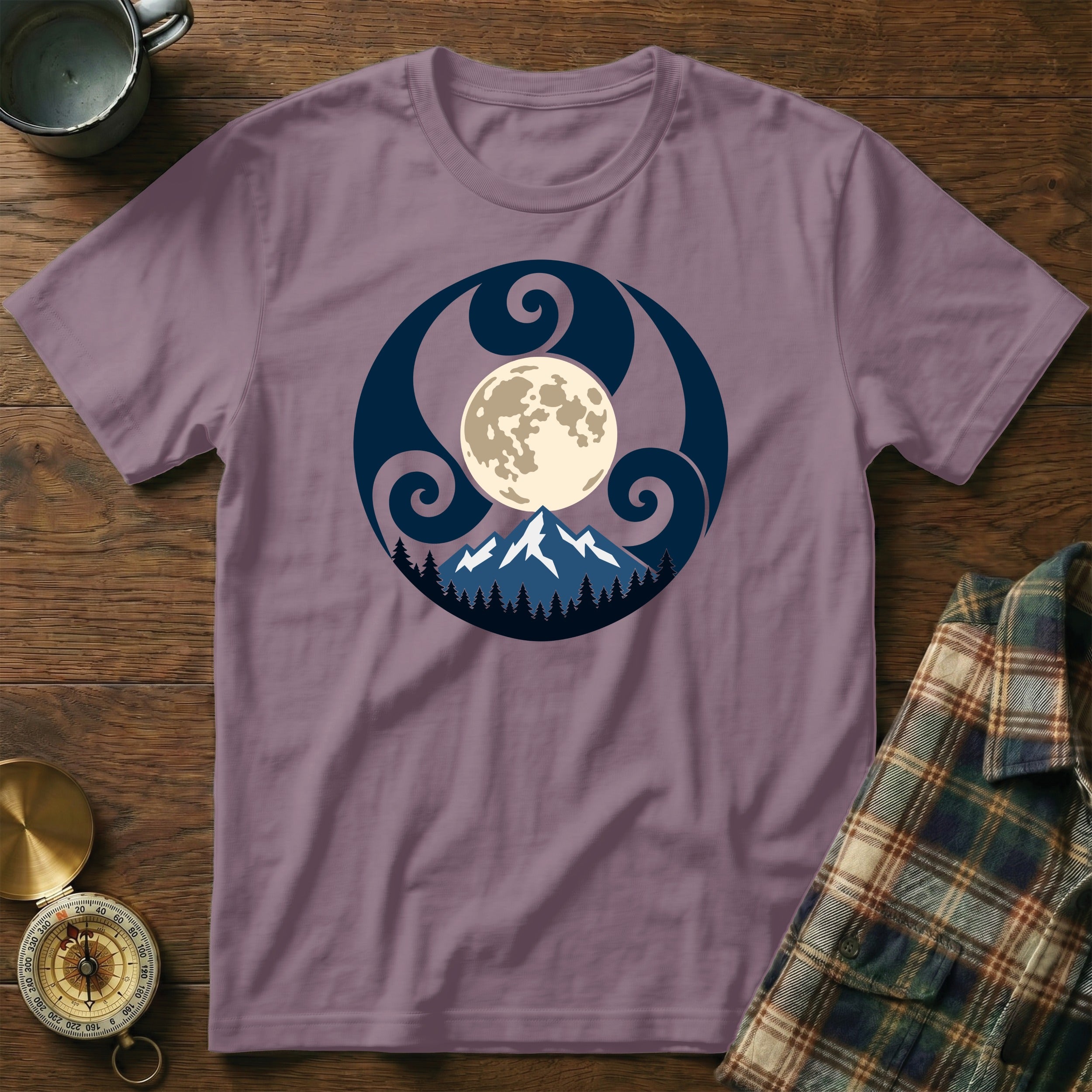Purple t-shirt with a circular print of a moon over mountains and trees.