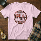 Pink t-shirt with circular "ROOTED & FREE" graphic.