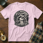 Pink t-shirt with a graphic of a raccoon taking a selfie and text saying "NOT A PHOTOBOMB."